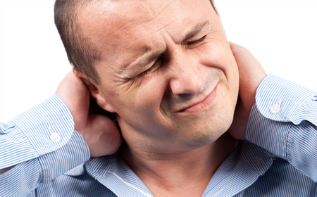 Texte alternatif : "Un homme se tenant la nuque avec une expression de douleur sur son visage, illustrant des douleurs cervicales.